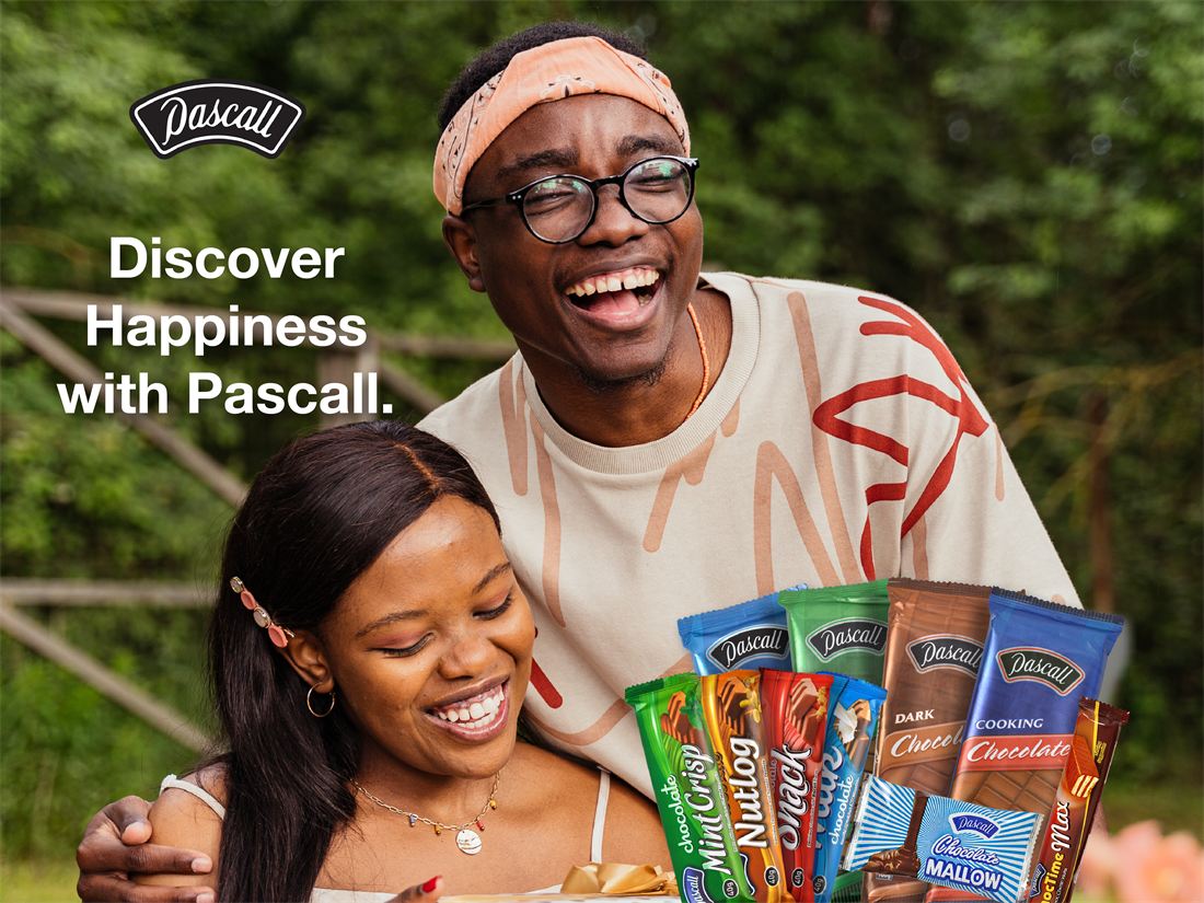 A couple laughing together with an armful of Pascall chocolate bars
